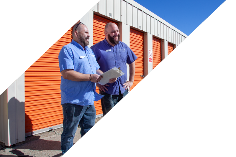 slash-people Two service representatives with a clipboard in front of the orange storage containers